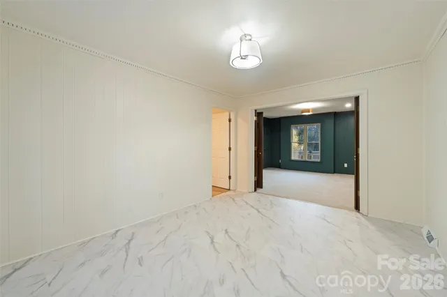 a view of an empty room with a chandelier fan