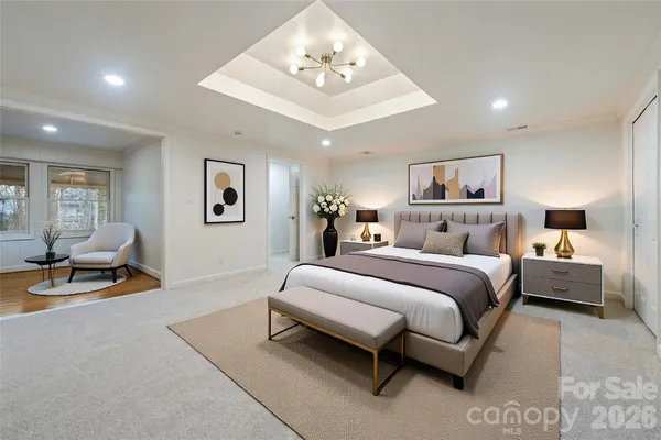 a bedroom with a bed a couch and a chandelier