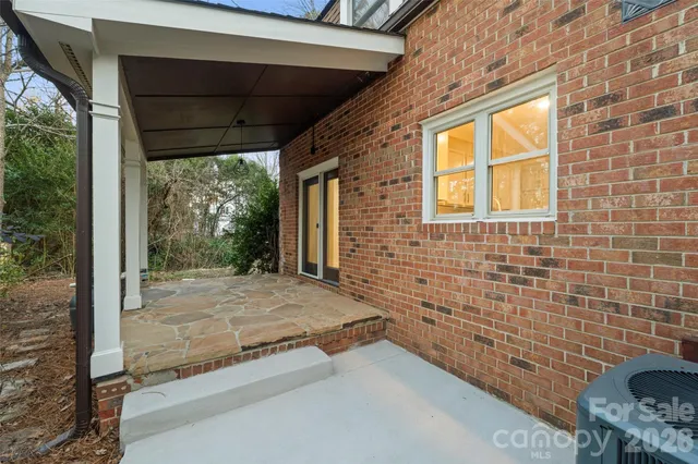 a view of a porch with a table and chairs and floor to ceiling window