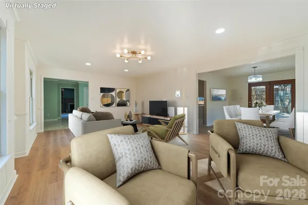 a living room with furniture or chandelier and a wooden floor