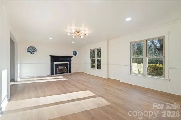 a view of an empty room with a fireplace and a window