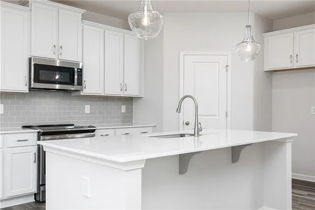 a kitchen with stainless steel appliances granite countertop white cabinets and stove