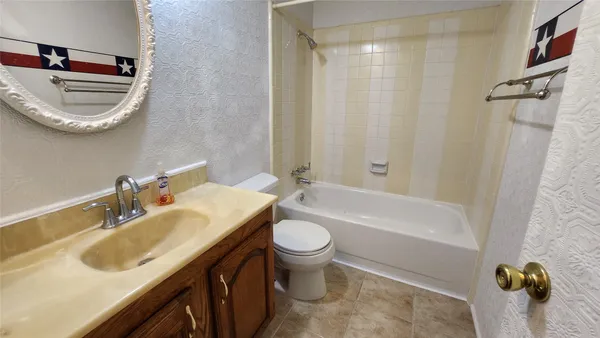 an empty room with a chandelier fan and windows