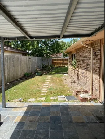 a view of a backyard with potted plants and large tree
