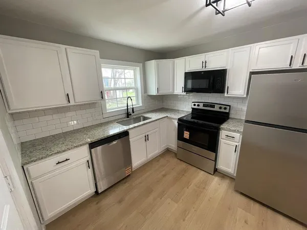 a kitchen with white cabinets and white appliances