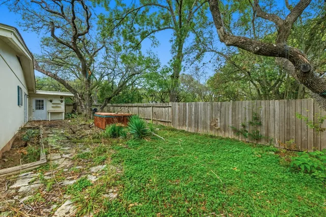 a backyard of a house with table and chairs
