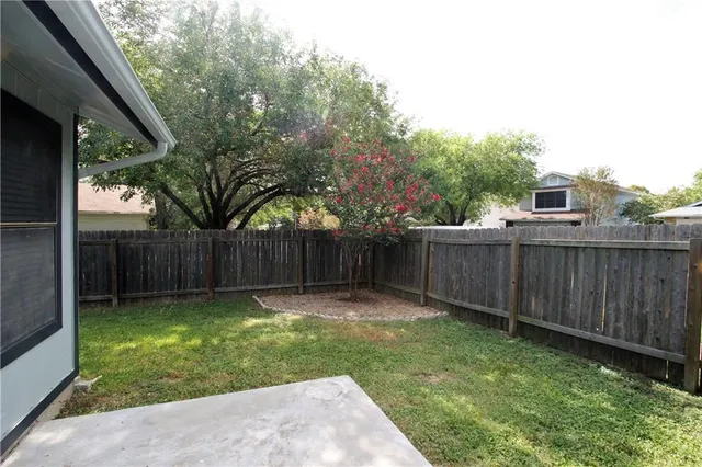 a view of a backyard with a small cabin and wooden fence