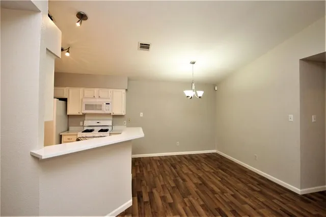a room with a wooden floor and chandelier