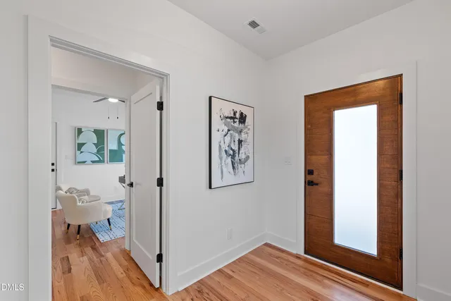 a view of a hallway with bathroom and wooden floor