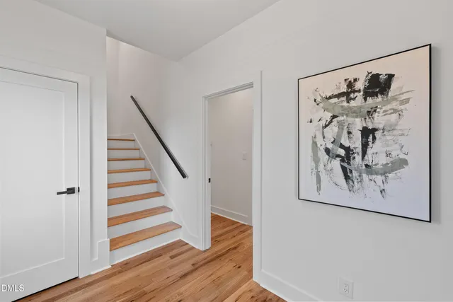 a view of a hallway with wooden floor and front door