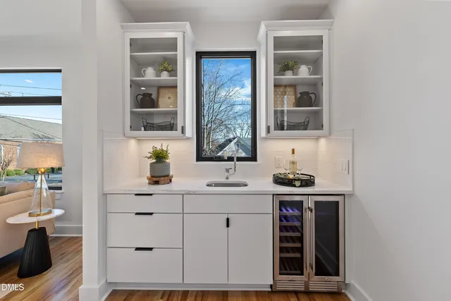 a view of a kitchen with cabinets stainless steel appliances wooden floor and a window