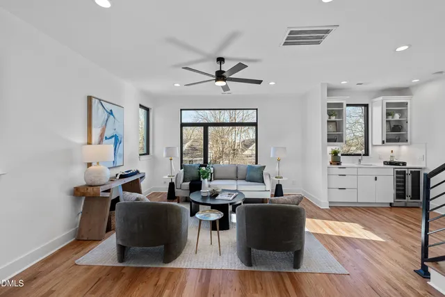 a large kitchen with stainless steel appliances a refrigerator a stove a sink dishwasher with a dining table and chairs with wooden floor