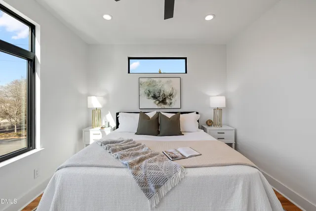 a view of an empty room with window and wooden floor