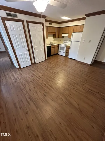 a view of a kitchen with wooden floor and electronic appliances