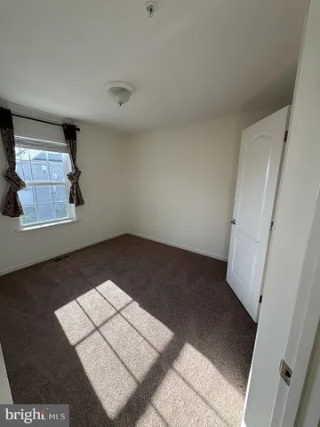 an empty room with windows and ceiling fan