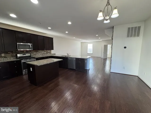 a large kitchen with stainless steel appliances granite countertop a stove and a sink
