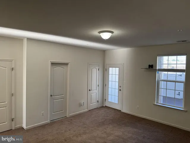 an empty room with windows and cabinet