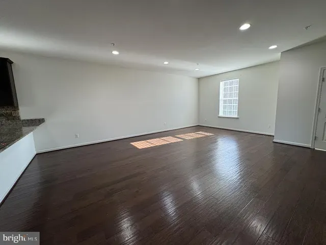 an empty room with wooden floor and a window