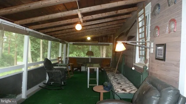a view of a porch with furniture and a yard