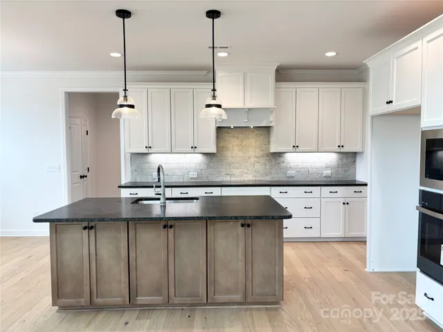 a kitchen with stainless steel appliances granite countertop a sink a stove and a refrigerator