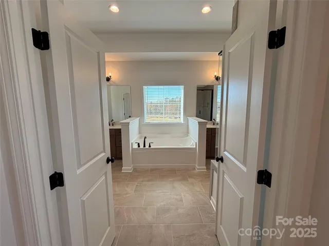 a bathroom with a tub sink and mirror