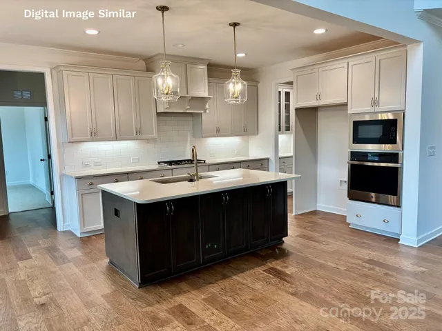 a kitchen with kitchen island granite countertop a stove and a sink