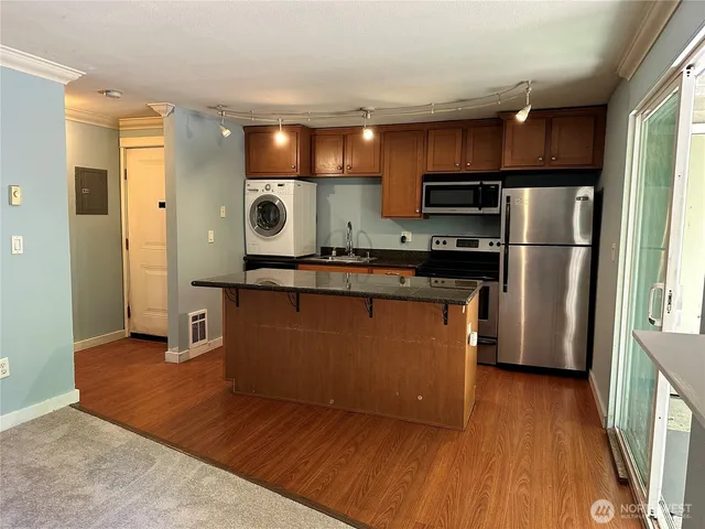 a kitchen with stainless steel appliances granite countertop a refrigerator a sink and a stove
