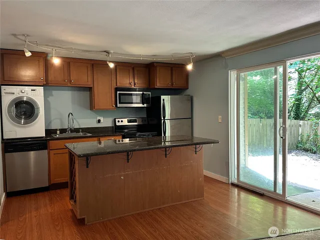 a kitchen with stainless steel appliances granite countertop a stove a sink and a refrigerator