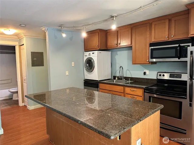 a kitchen with stainless steel appliances granite countertop a sink a stove and a microwave