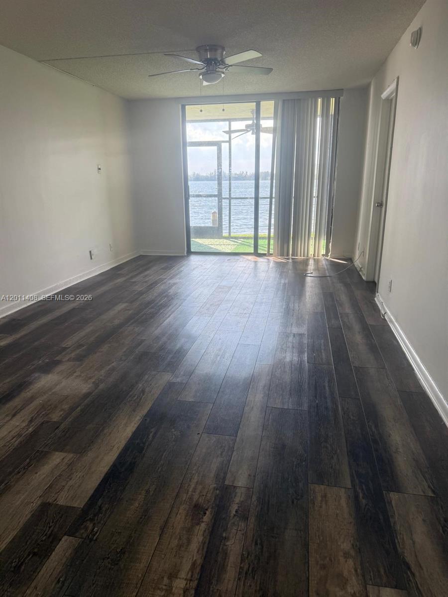 109 Lake Emerald Drive, Unit 102 Oakland Park, FL 33309 - Photo 6 of 13 wooden floor in an empty room with a window