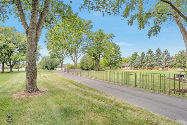 a view of a wooden house with a yard and lawn chairs