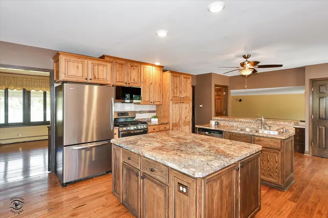 a kitchen with a stove a refrigerator a sink a dining table and chairs