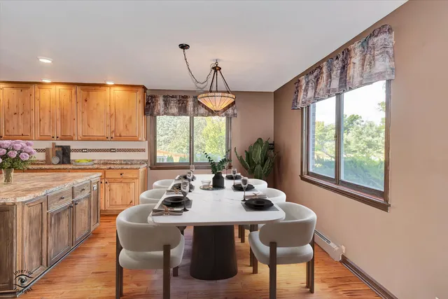 a kitchen with stainless steel appliances a table and chairs in it