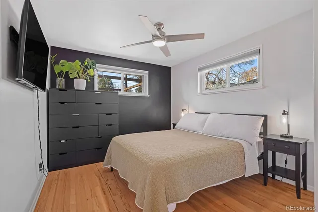 a bedroom with a bed and a flat tv screen on dresser