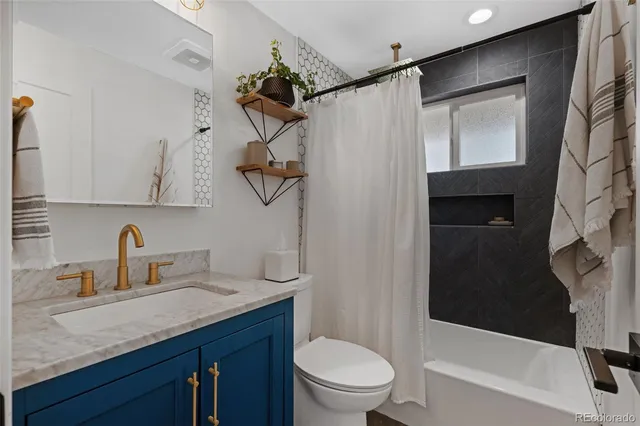 a bathroom with a granite countertop sink toilet and shower