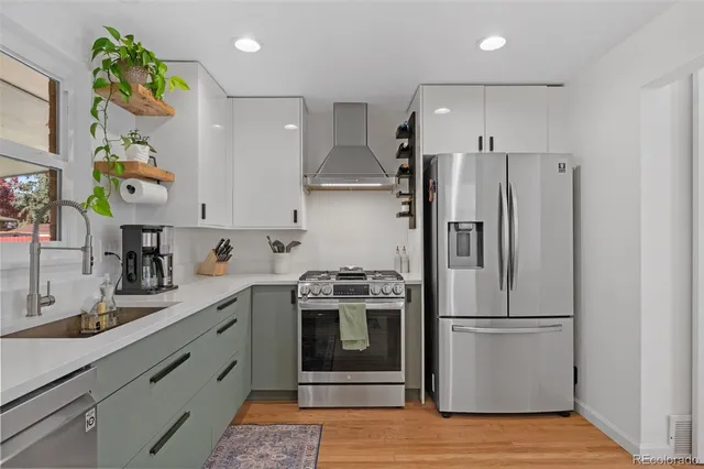 a kitchen with stainless steel appliances granite countertop a refrigerator and a stove