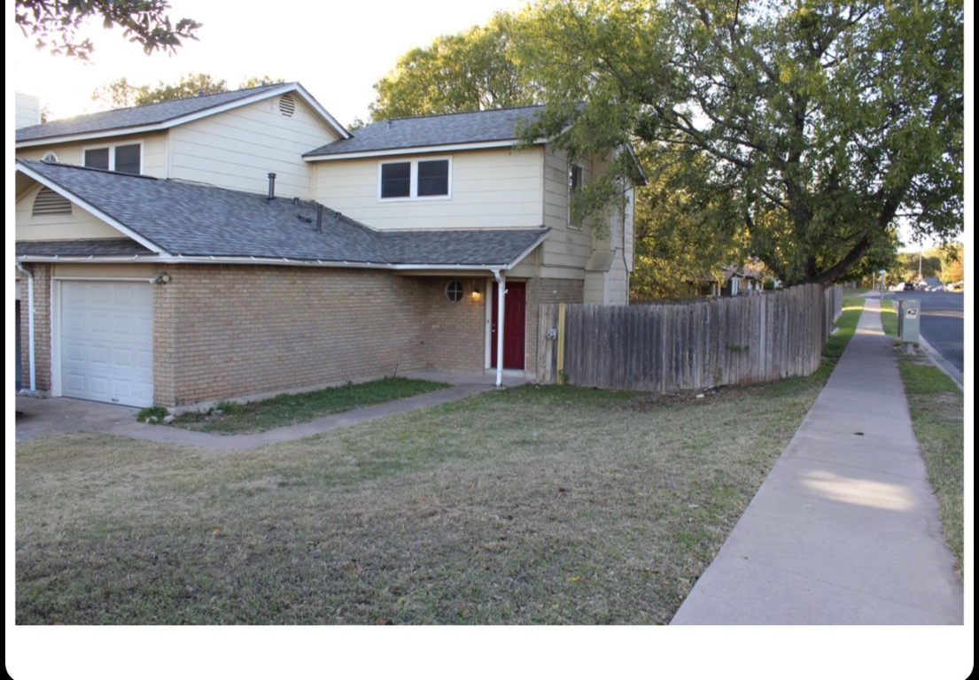 Traditional-style house with brick siding, a garage, and a shingled roof