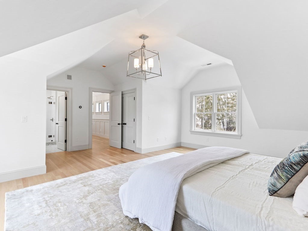 31 Karen Road Newton, MA 02468 - Photo 31 of 41 a spacious bedroom with a bed and a chandelier