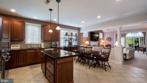 a kitchen with granite countertop sink table and chairs