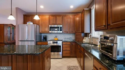 a kitchen with stainless steel appliances granite countertop a stove top oven a sink and dishwasher