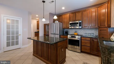a kitchen with stainless steel appliances granite countertop a refrigerator a stove a sink and a microwave