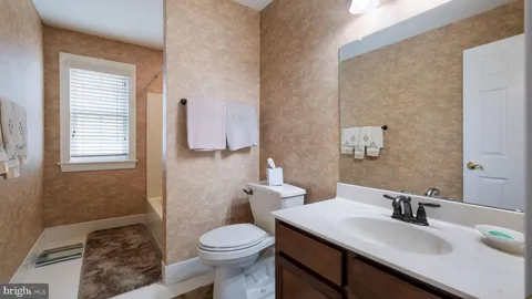 a bathroom with a sink a toilet and mirror