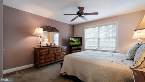 a bed room with a bed and a mirror on the dresser
