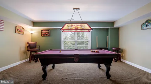 a living room with furniture and a dining table with projector the kitchen