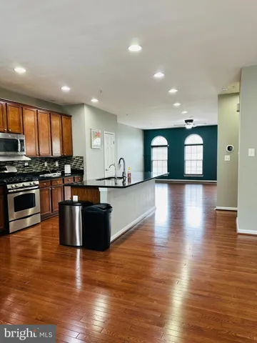 a kitchen with stainless steel appliances granite countertop a stove top oven and a refrigerator