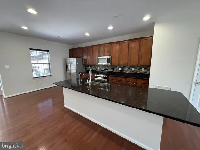 a kitchen with stainless steel appliances a refrigerator and a stove top oven