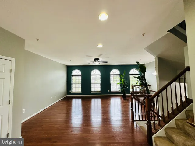 a view of a hallway with wooden floor and windows