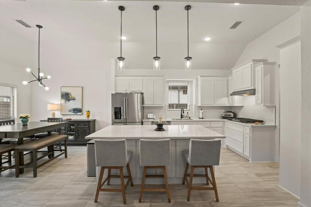 1714 Highwood Road Forney, TX 75126 - Photo 10 of 30 a kitchen with stainless steel appliances kitchen island granite countertop a table chairs sink and cabinets