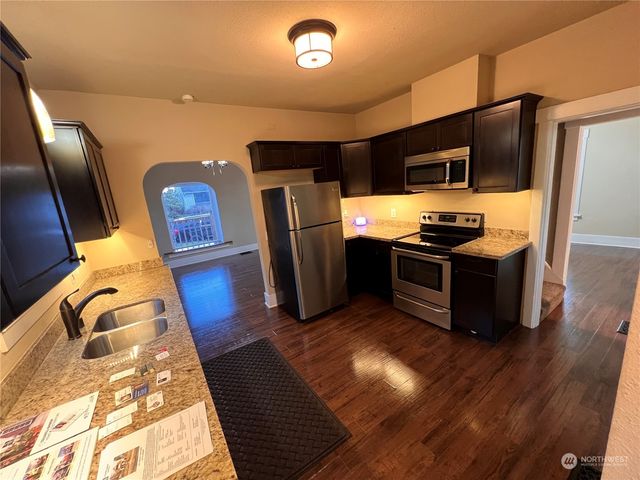 a kitchen with stainless steel appliances wooden cabinets a sink and a refrigerator