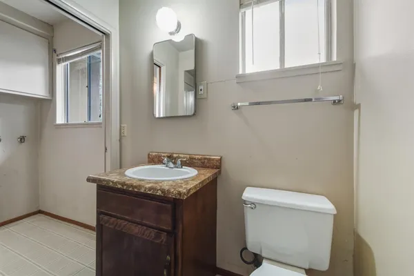 a bathroom with a toilet sink vanity and mirror